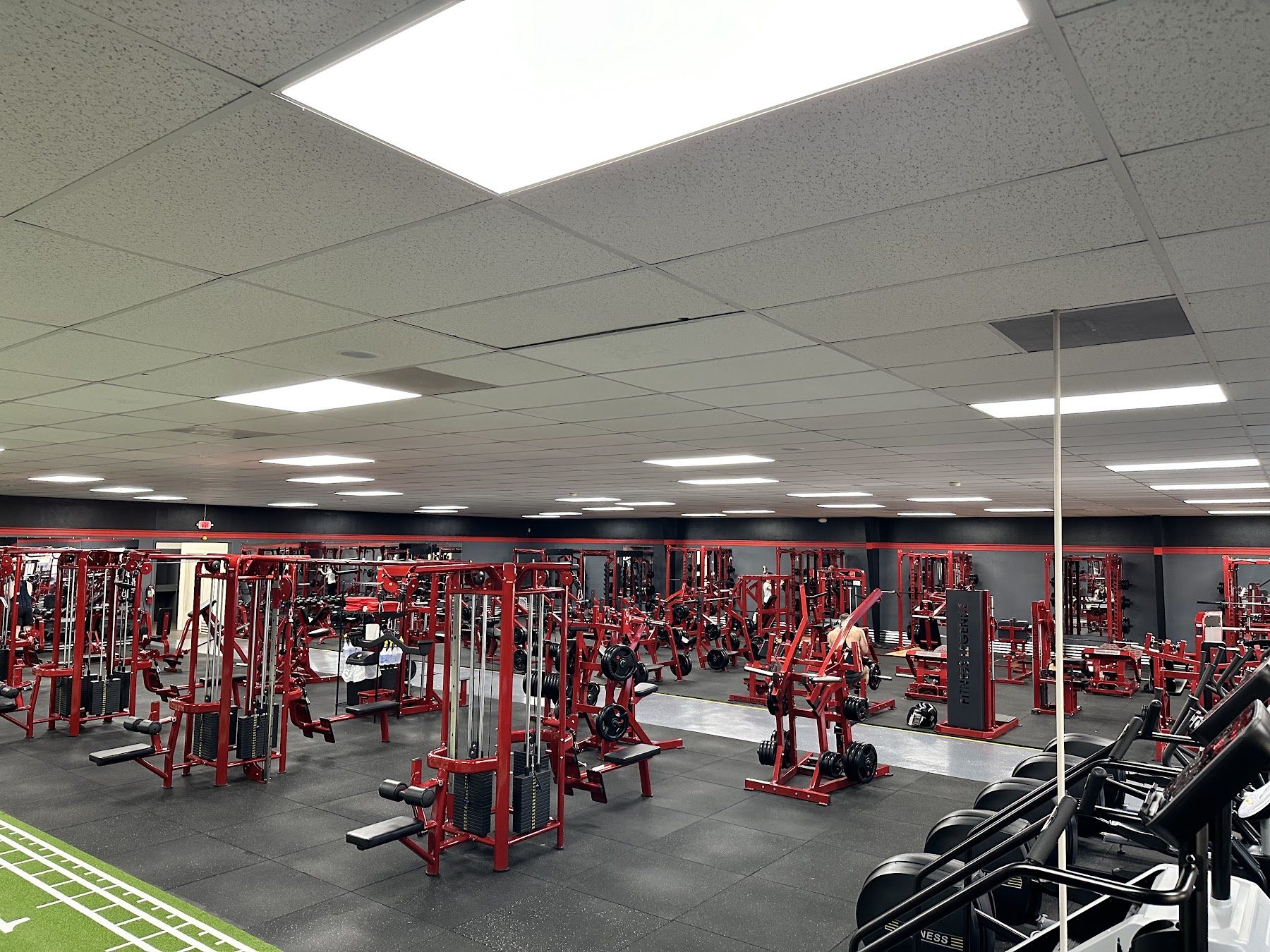 The main training floor at Fitness Legendz, filled with matching red custom equipment on black rubber flooring