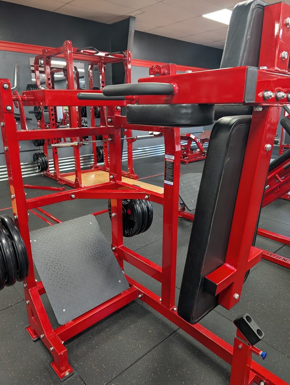 Custom red plate-loaded machine with LEGENDZ branded on the frame